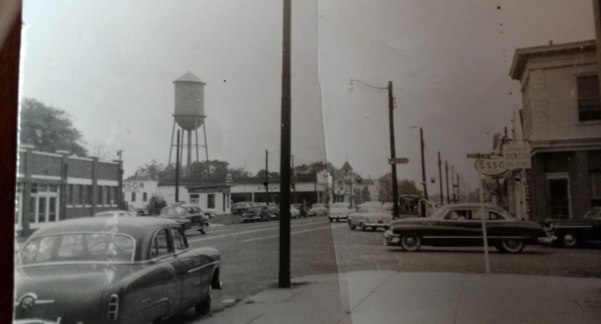 water tower - Antique style photo with cares in the foreground and the water tower in the background. 