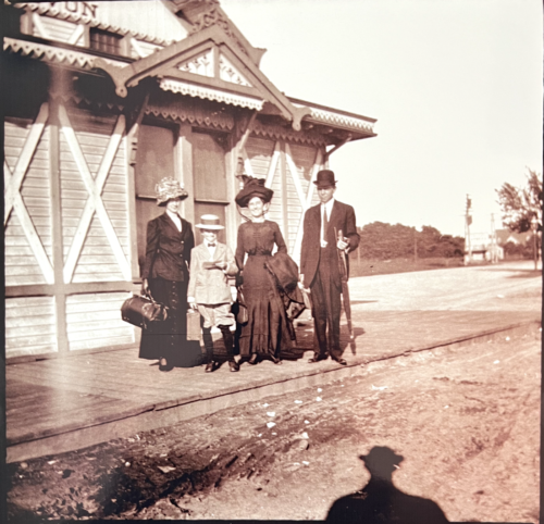 Avon train station - Old photo of people standing in period appropriate dress on the platform